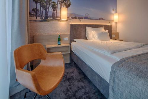 ein Hotelzimmer mit einem Bett und einem Stuhl in der Unterkunft Best Western Hotel Wiesbaden in Wiesbaden