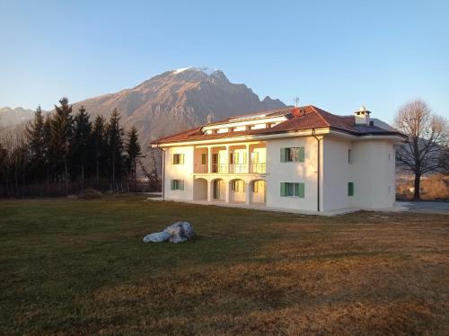 a house in a field with a mountain in the background at CORTE dei SANTI suite in Lèvego