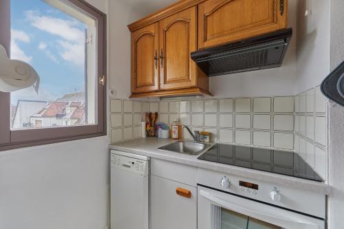 une petite cuisine avec un évier et une fenêtre dans l'établissement Le 32 de Cabourg - A 400 m de la plage, à Cabourg