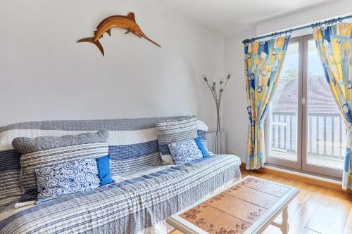 un salon avec un canapé et une fenêtre dans l'établissement Le 32 de Cabourg - A 400 m de la plage, à Cabourg