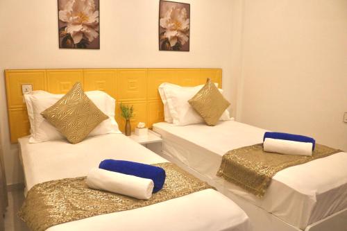 a room with two beds with towels on them at Sea Sun Stay in Maafushi