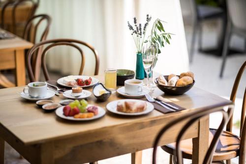 a wooden table with plates of food on it at Romantik Hotel Jagdhof in Caldaro