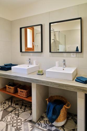 une salle de bain avec deux lavabos et un miroir dans l'établissement Les bergeries alivaccia, à Figari