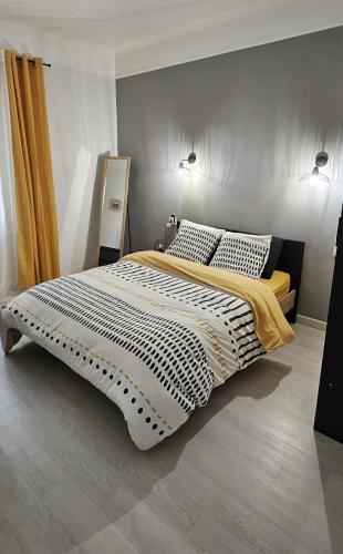 - une chambre dotée d'un grand lit avec des draps noirs et blancs dans l'établissement A proximité de toutes commodités, à Rivesaltes