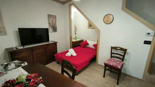 a living room with a red couch and a tv at Casa vacanze Dimora Castello 19 in Rotonda
