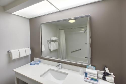 a bathroom with a sink and a mirror at Four Points by Sheraton Charlotte/Pineville in Charlotte