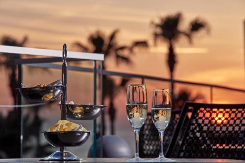 a table with two glasses of champagne on a table at Atlantica Golden Beach Hotel - Adults Only in Paphos