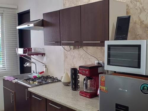 a kitchen with a stove and a microwave on a counter at Departamento Inteligente en Colonia Cerrada Vigilancia 7X24 in Monterrey