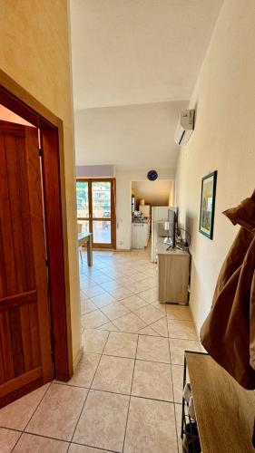 a living room with a door and a tiled floor at Appartamento Quadrifoglio in Castelsardo