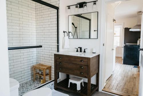 a bathroom with a sink and a mirror at Park and Mill - Hot Tub and Bocce Court in Bloomfield