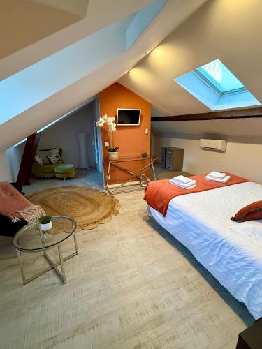 - une chambre avec un grand lit et une lucarne dans l'établissement Les Lys D'or Appartement 3 chambres, à Saumur