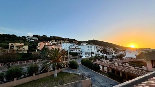 a view of a city with the sunset in the background at Appartamento Quadrifoglio in Castelsardo
