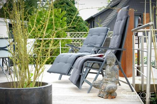 a group of chairs sitting on a porch at Seekoje - Haus Am Möhnesee in Möhnesee