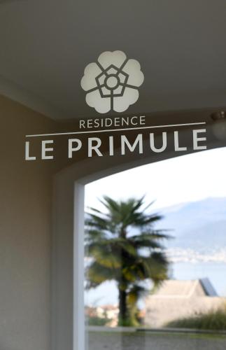 a sign on the door of a building with a palm tree at Residence Le Primule in Stresa
