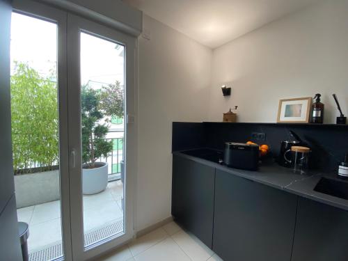 a kitchen with a counter with a sink and a window at New Apartment Disneyland Paris Panoramic view 8 PAX, 2 parking in Serris