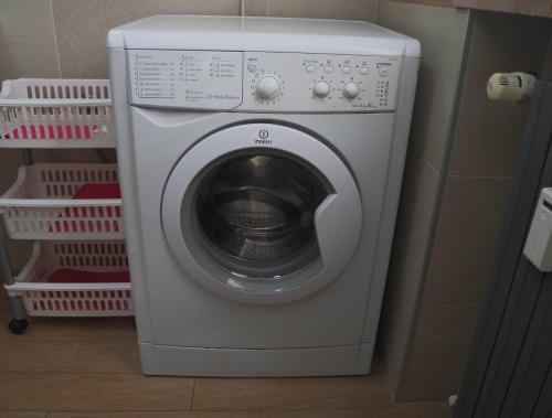 a white washing machine in a room with baskets at Casa Migliardi Colors in Nizza Monferrato