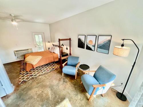 a bedroom with a bed and two blue chairs at Court Yard Studio Smithville in Smithville