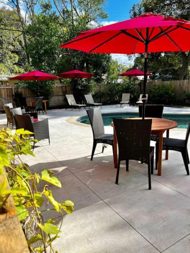 a patio with a table and chairs with red umbrellas at Court Yard Studio Smithville in Smithville