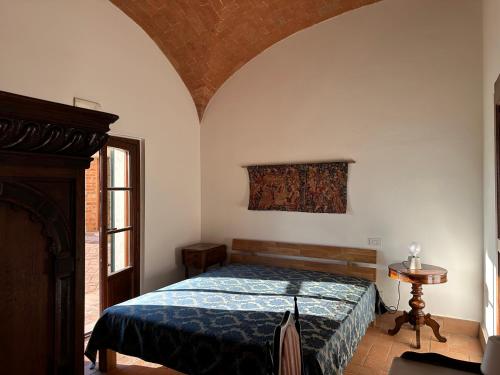 Un dormitorio con una cama con un edredón azul. en Fornace del Conte, en Abbadia di Montepulciano