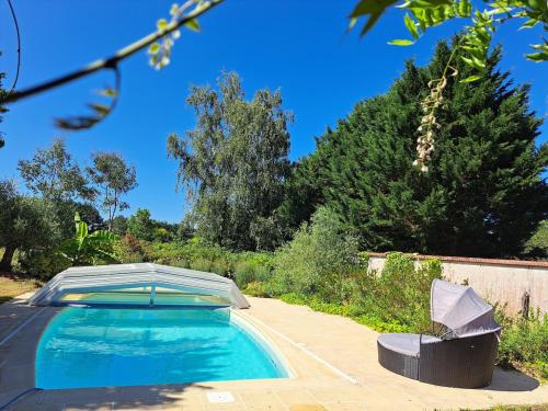 - une piscine avec un parasol dans la cour dans l'établissement Les gîtes de Saint-ange, à Pezou