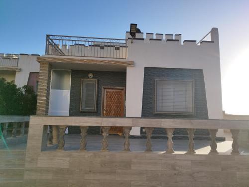 a house with a wooden deck in front of it at Palma Aglou in Tiznit