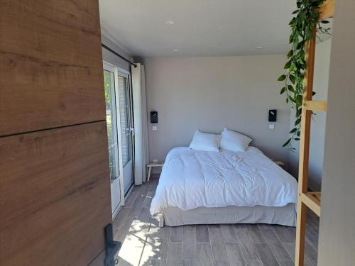 - une chambre avec un lit doté de couvertures et d'oreillers blancs dans l'établissement Les gîtes de Saint-ange, à Pezou