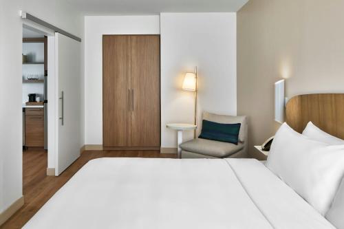 a hotel room with a large bed and a chair at Element Atlanta Perimeter Center in Atlanta