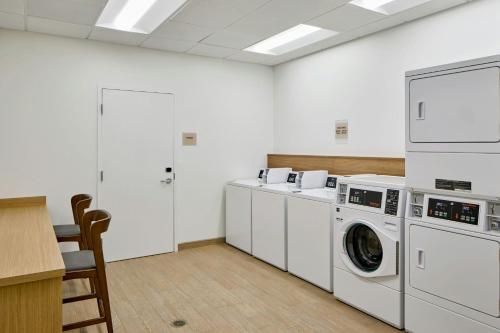 a laundry room with white washing machines and a table at Element Atlanta Perimeter Center in Atlanta