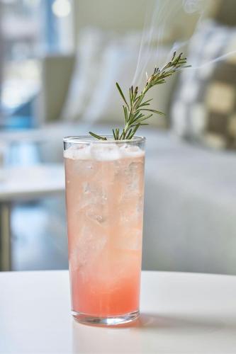 a drink with a rosemary garnish in a glass at Element Atlanta Perimeter Center in Atlanta