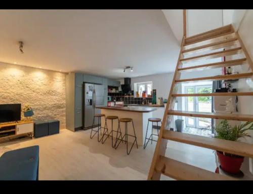 un salon avec un escalier et une cuisine dans l'établissement Maison troglodyte, à Poitiers