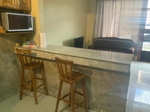 a kitchen with a marble counter and two stools at Pinky s Place Alajuela City Airport Costa Rica in Alajuela City