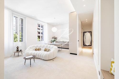 un salon blanc avec un canapé blanc et une table dans l'établissement Le Mané - Haussmannien Centre Cannes accommodation, à Cannes