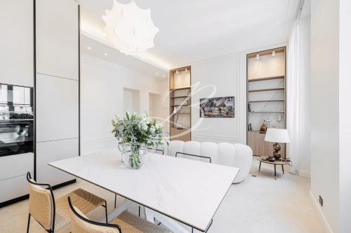 une salle à manger blanche avec une table et des chaises blanches dans l'établissement Le Mané - Haussmannien Centre Cannes accommodation, à Cannes