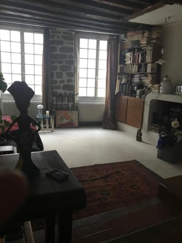 un salon avec des fenêtres et un mur en pierre dans l'établissement Lanneau12, à Paris