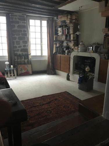 un salon avec une cheminée et un mur en pierre dans l'établissement Lanneau12, à Paris