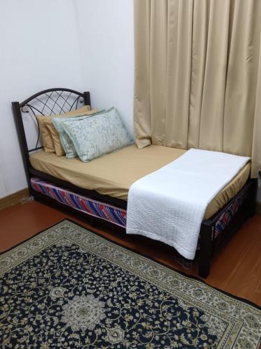 a small bed in a room with a rug at HOMESTAY ANAK SYURGA AMzAR MALAY ONLY in Kangar