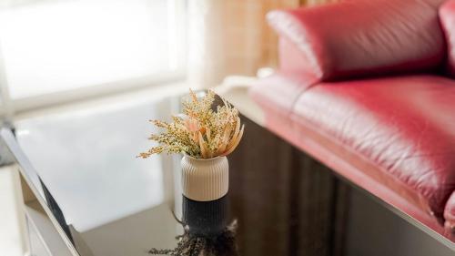 a vase with flowers on a table next to a couch at Relaxing 3BR Family Home near Zoo with Netflix WiFi in Tupai