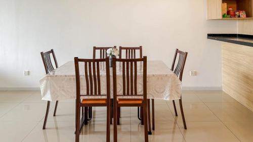 a dining room table with four chairs and a white table cloth at Relaxing 3BR Family Home near Zoo with Netflix WiFi in Tupai