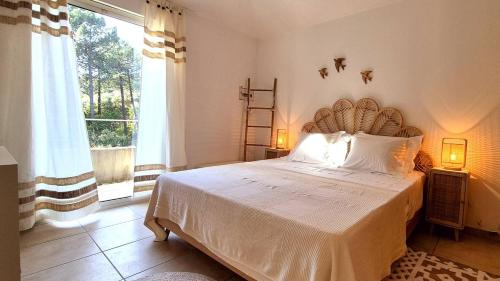 une chambre avec un grand lit et une grande fenêtre dans l'établissement Appartement Ruscana, 4 pers, 90 m plage, à Pinarellu