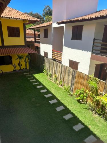 a lawn in front of a house with a fence at Pousada Cordel de Itaúnas in Itaúnas