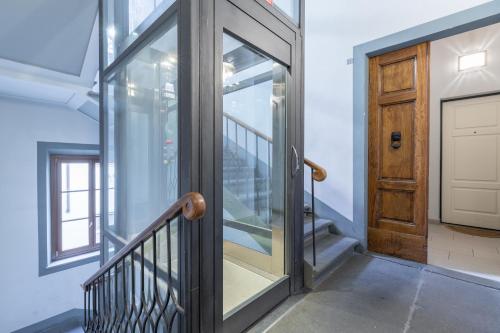 a hallway with a wooden door and a staircase at Residenza Storica 18 min Di Treno Per Firenze in Prato