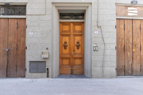 a wooden door on a building with two doors at Residenza Storica 18 min Di Treno Per Firenze in Prato