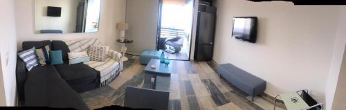 a living room with a couch and a table at Renovated apartment Generator is included beach in Jounieh