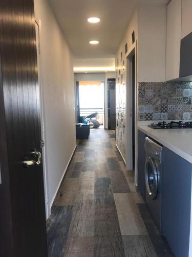 a hallway of a kitchen with a washer and dryer at Renovated apartment Generator is included beach in Jounieh