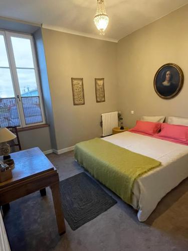 une chambre avec un lit, une table et une fenêtre dans l'établissement Ferme de Maillezais, à LʼHoumeau