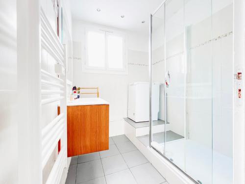 une salle de bain avec une douche en verre et un lavabo dans l'établissement Le Germain - Logement 3 pièces, à Cannes