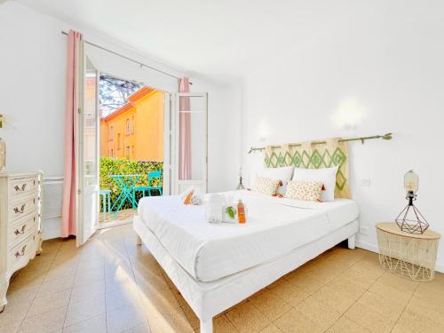 une chambre blanche avec un lit et un balcon dans l'établissement Le Germain - Logement 3 pièces, à Cannes