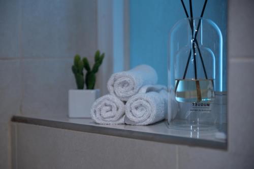 un estante en el baño con toallas y un jarrón en Modern 3 Bedroom Oasis in Swieqi by ELDI, en Is-Swieqi