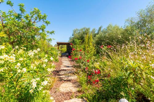 a path through a garden with flowers at Laranjal Farm House in Moncarapacho