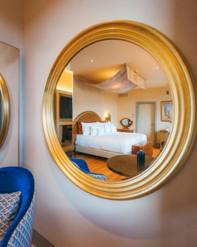 a bedroom with a bed and a round mirror at La Monastica Resort & Spa in Borgo a Buggiano